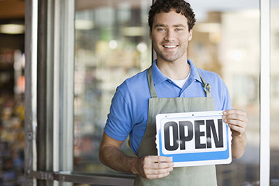 Business owner holding "Open" sign